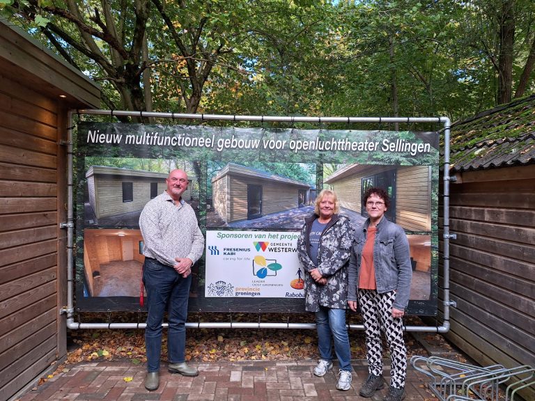 Leden Openluchttheater Sellingen bij spandoek sponsoren clubhuis.